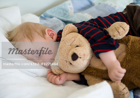 Boy sleeping with his teddy bear