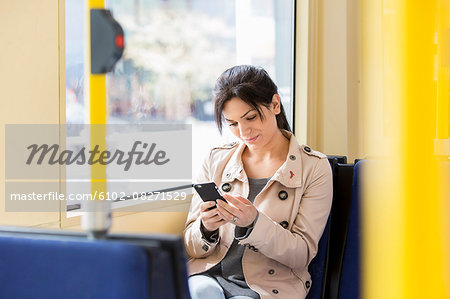 Woman using cellphone in tram