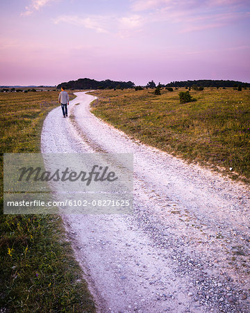 Man walking on dirt track at dusk