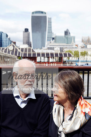 Senior couple, modern buildings on background