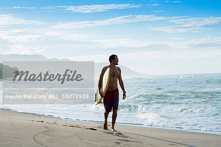 Central America, Costa Rica, Puntarenas, Nicoya peninsula, a male surfer on a beach near Santa Teresa