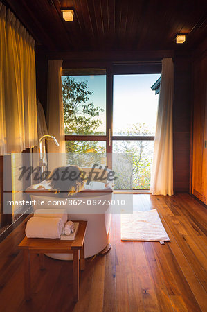 Dominica, St John Parish, Portsmouth. A young lady relaxes in the bath in a Zabuco Villa at Secret Bay. .