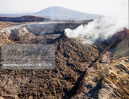 Ethiopia, Erta Ale, Afar Region. The smoking fumarole of one of the two active volcanic pit craters of Erta Ale (foreground) with Borale Ale Volcano in the distance.