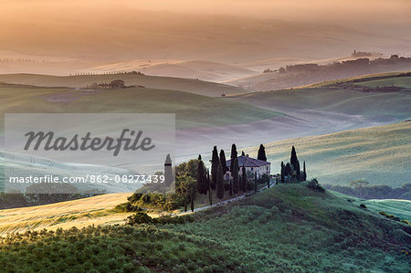 Val d'Orcia, Tuscany, Italy. A lonely farmhouse with cypress and olive trees, rolling hills. Val d'Orcia, Tuscany, Italy. A lonely farmhouse with cypress and olive trees, rolling hills.
