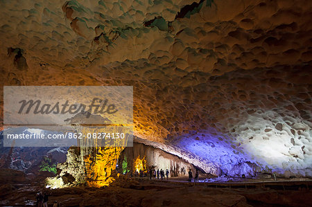 Vietnam, Ha Long Bay, Hang Sung Sot Caves. A group of tourist wander through the cavernous caves inside one of Ha Long Bay's famous karsts.