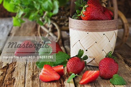 ripe strawberries and mint leaves on a wooden background. berries from his garden.health and diet food. selective focus