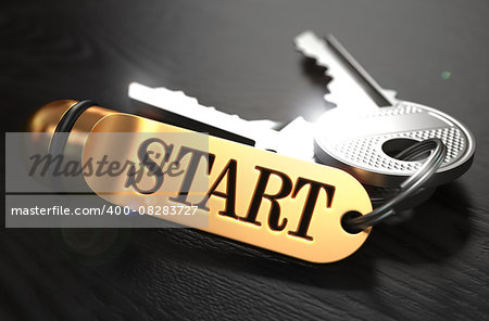 Keys and Golden Keyring with the Word Start over Black Wooden Table with Blur Effect.