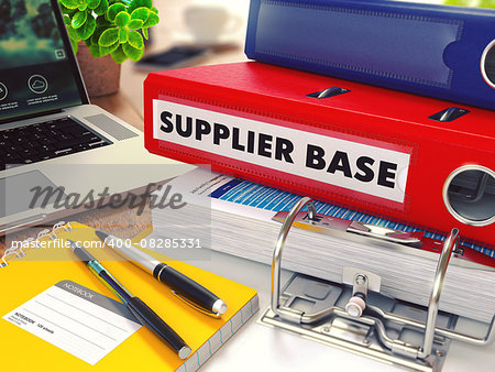 Supplier Base - Red Office Folder on Background of Working Table with Stationery, Laptop and Reports. Business Concept on Blurred Background. Toned Image.
