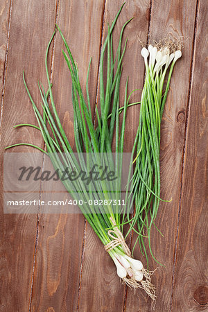 Fresh garden spring onion on wooden table. Top view