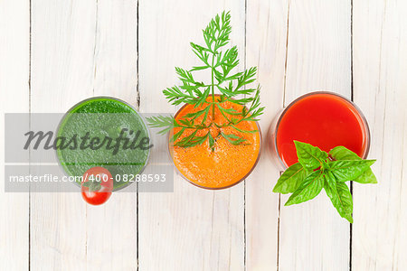 Fresh vegetable smoothie on wooden table. Tomato, cucumber, carrot. Top view