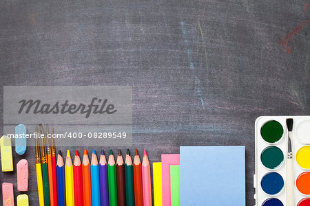 School supplies on blackboard background. Top view with copy space