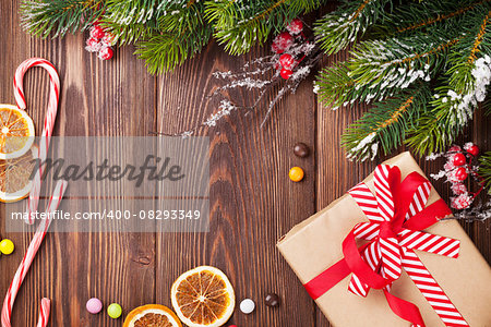 Christmas wooden background with snow fir tree, decor and gift box