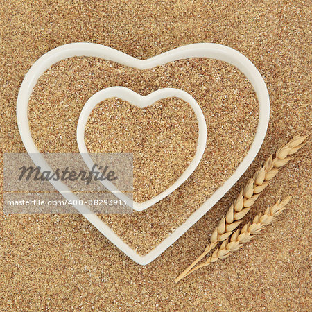 Wheatgerm in heart shaped white porcelain dishes with wheat sheaths forming an abstract background.