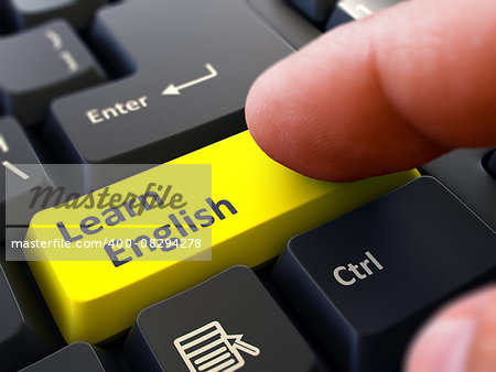 Learn English Button. Male Finger Clicks on Yellow Button on Black Keyboard. Closeup View. Blurred Background.