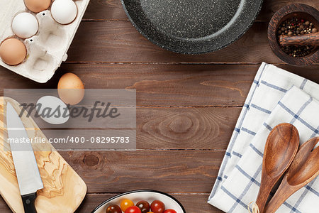 Cooking ingredients and utensils on wooden table. Top view with copy space