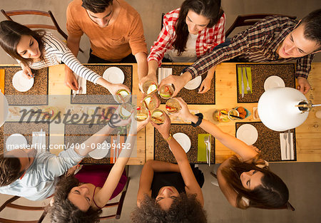 Group of people toasting and looking happy at a restaurant