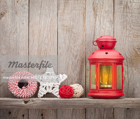 Christmas candle lantern and decor in front of wooden wall with copy space