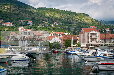 Monetengro traditional Mediterranean boats at fisherman's village and mountain landscape. Tivat.