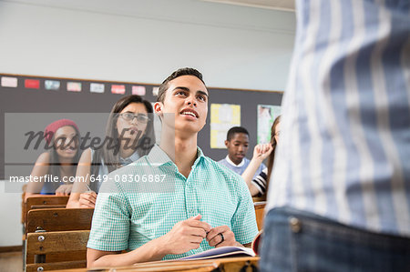 Male student talking to teacher in classroom