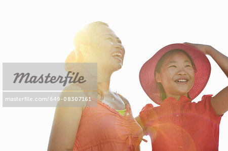 Happy mid adult woman and daughter in sunlight