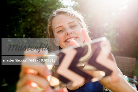 Teenage girl taking smartphone selfie in park