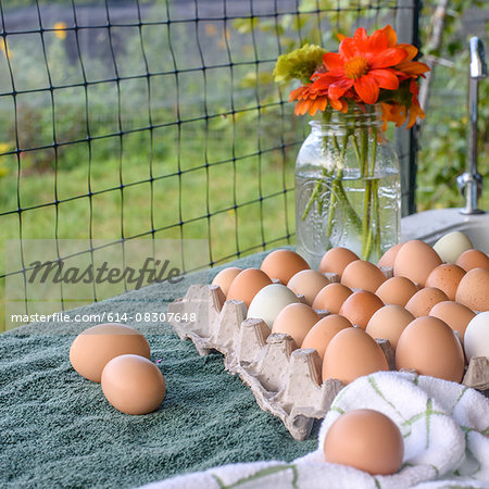 Flowers in bottle and tray of eggs on table