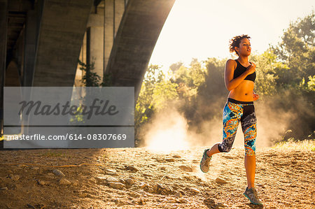 Jogger running under arch, Arroyo Seco Park, Pasadena, California, USA