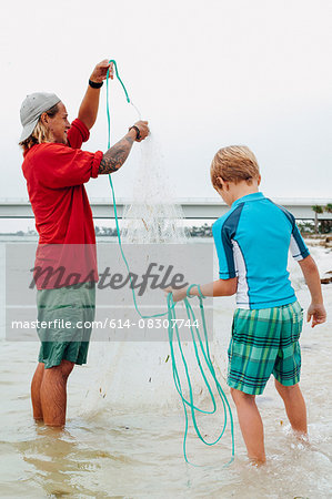 Teacher showing boy how to use cast net, Sanibel Island, Pine Island Sound, Florida, USA