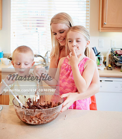 Family melting chocolate in mixing bowl