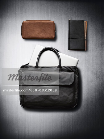Bags and notebook on metallic background in studio Bags and notebook on metallic background in studio
