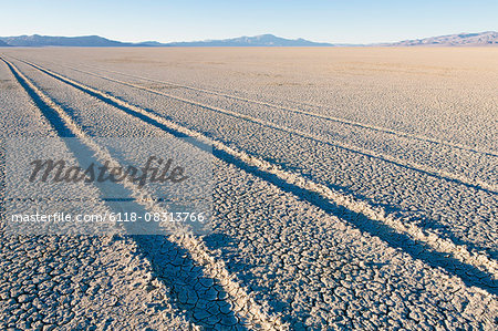 Tire tracks on the dry surface of the desert.