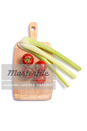 Fresh tomatoes and celery sticks on chopping board, top view isolated on white background