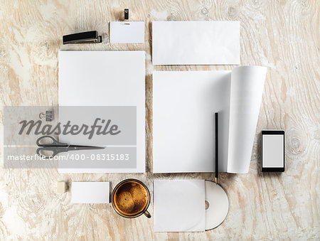 Photo of blank stationery and corporate identity template on light wooden background. For design presentations and portfolios. Top view.