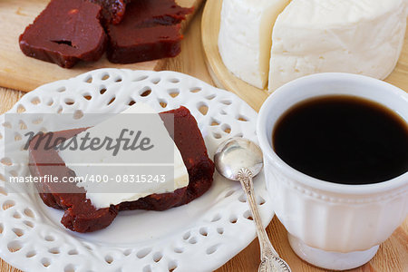 Brazilian dessert Romeo and Juliet, goiabada and Minas cheese with cup of coffee on wooden table. Selective focus