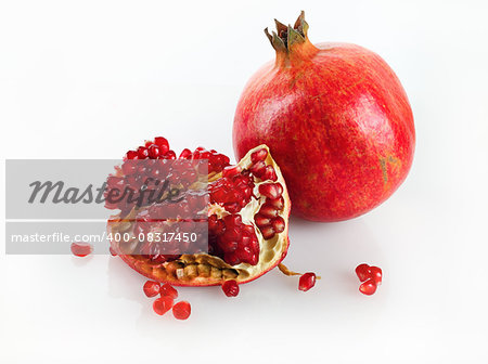 Delicious juicy ripe pomegranate and its half. Studio shot.