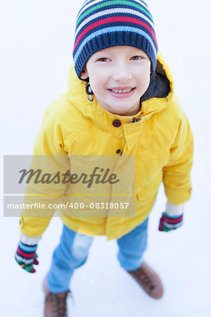 little boy enjoying cold winter weather and ice skating at outdoor rink