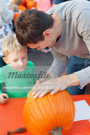 family of two enjoying pumpkin carving at halloween time