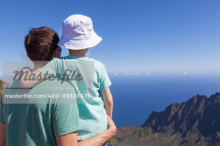 family of father and son enjoying kalalau valley together at kauai island, hawaii