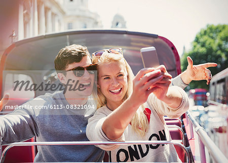 Couple taking selfie on double-decker bus in London