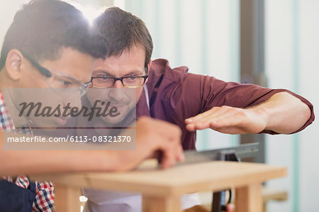 Carpentry teacher and student examining measurement