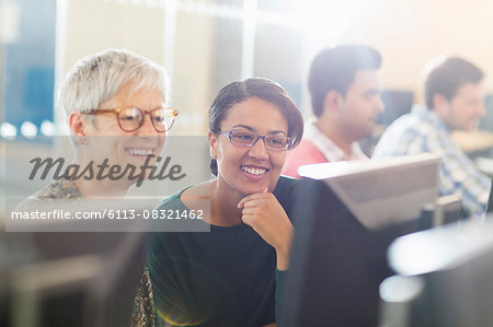 Smiling women at computer in adult education classroom