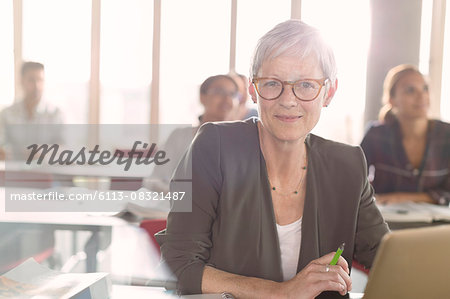 Portrait smiling senior woman at laptop in adult education classroom