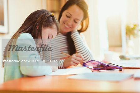 Mother watching daughter do homework