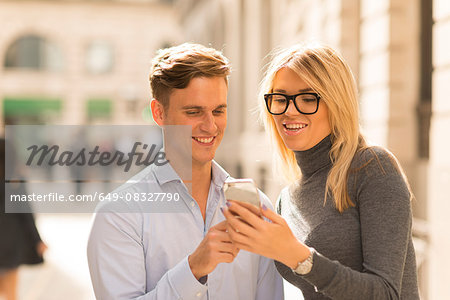 Couple sharing text message in street