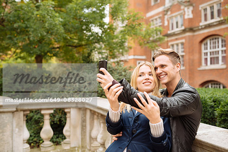 Young couple taking selfie outside Albert Hall, London, England, UK