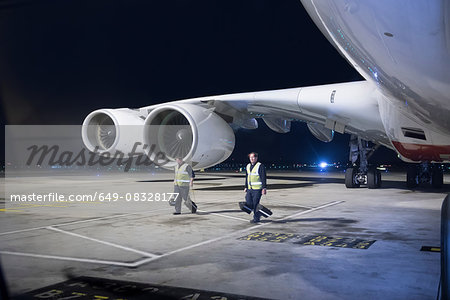 Ground crew removing wheel chocks from A380 aircraft at night