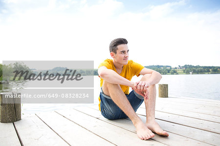 Portrait of young man sitting on jetty