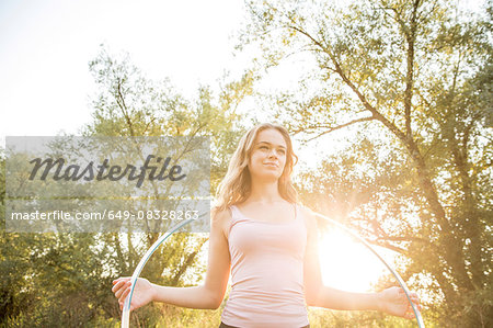 Young girl in rural environment, holding hula hoop