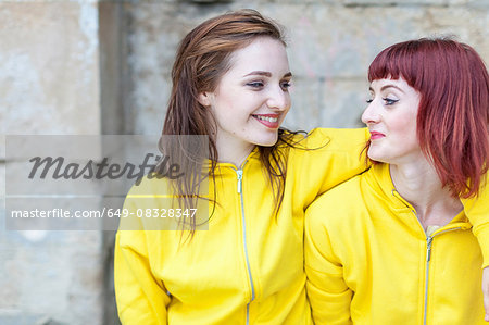 Young women smiling, stone wall in background