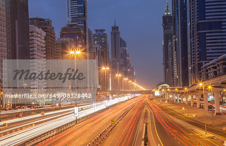 City highway and Dubai metro rail station at night, downtown Dubai, United Arab Emirates